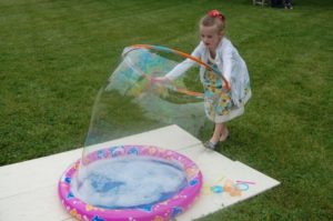 Summer Fun - child making bubbles with a hula hoop